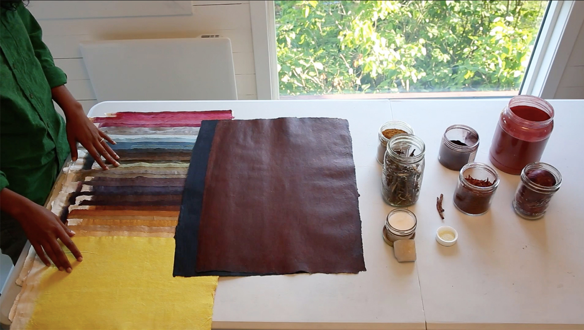 A white table with a stack of colourfully dyed pieces of paper stacked on top of each other.