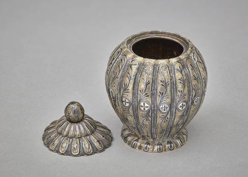 Lobed silver and gilded pot with floral design, with lid taken off.