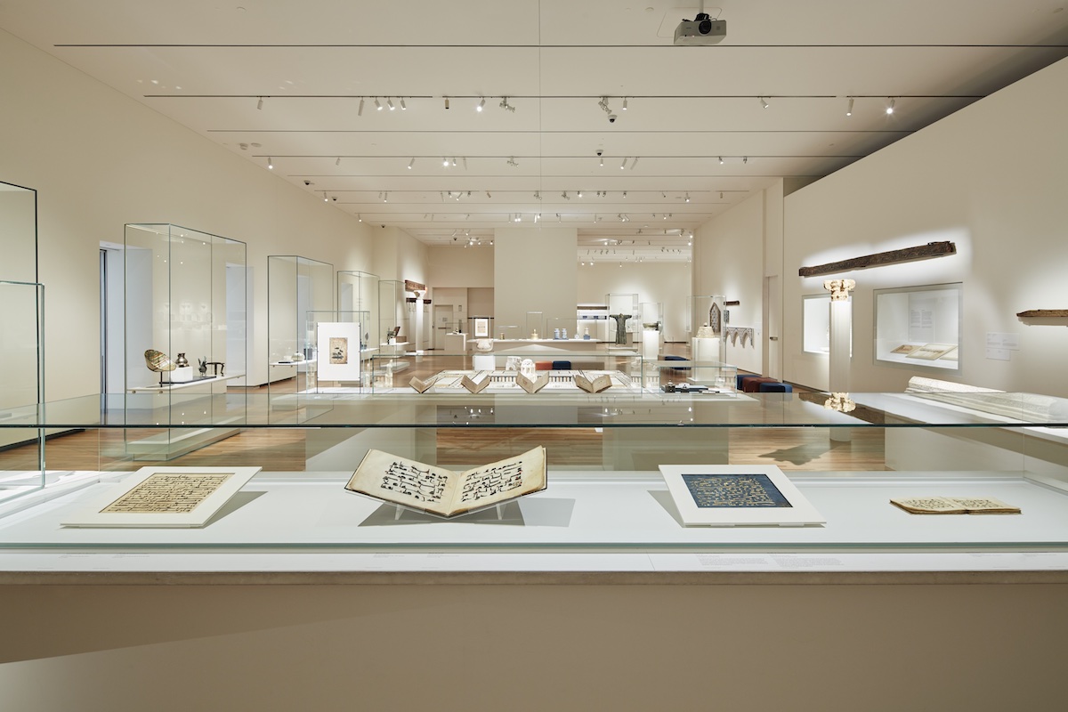 A museum case filled with folios and open books on display