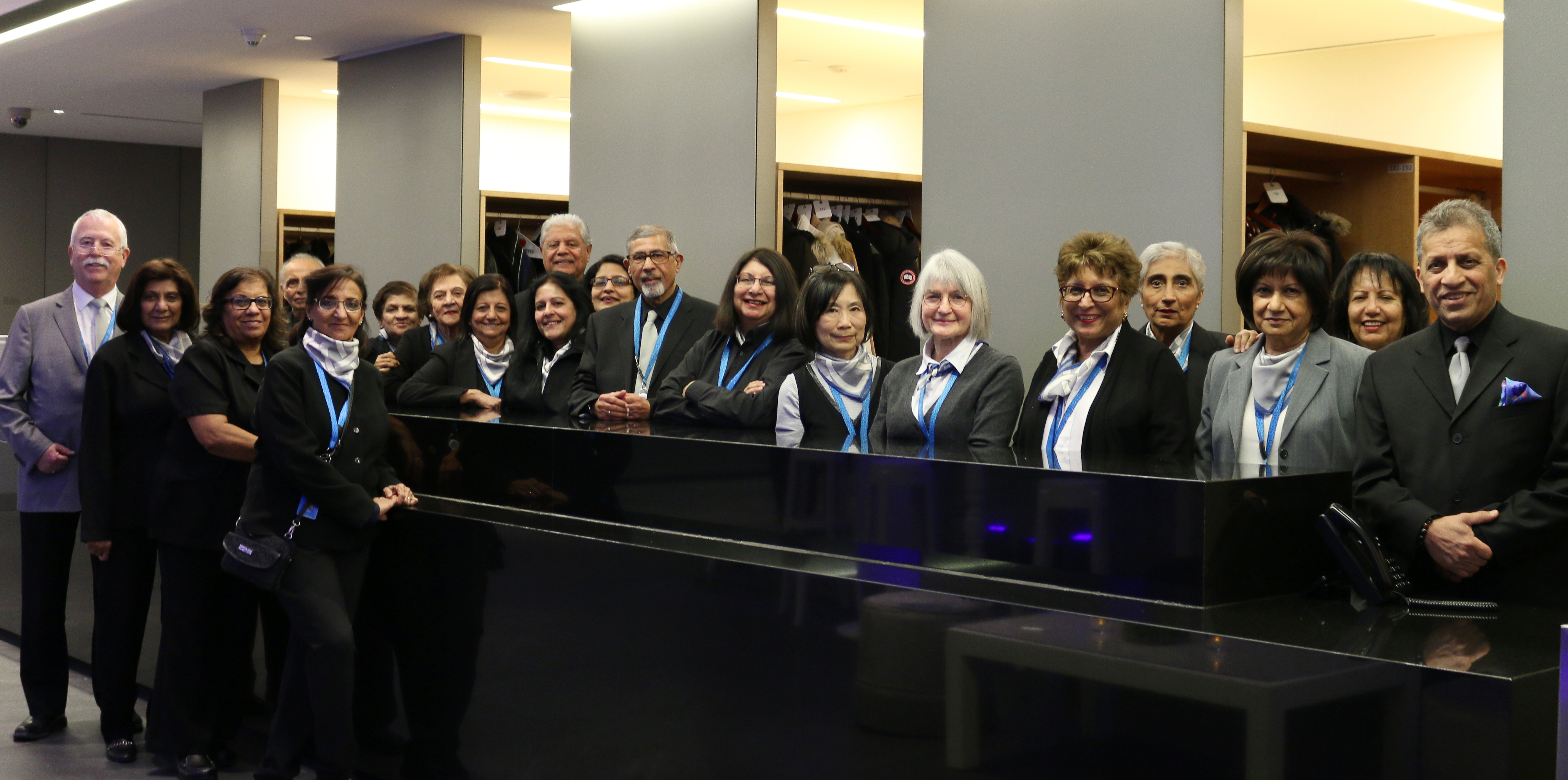 A group of smiling volunteers stand together inside of the Aga Khan Museum